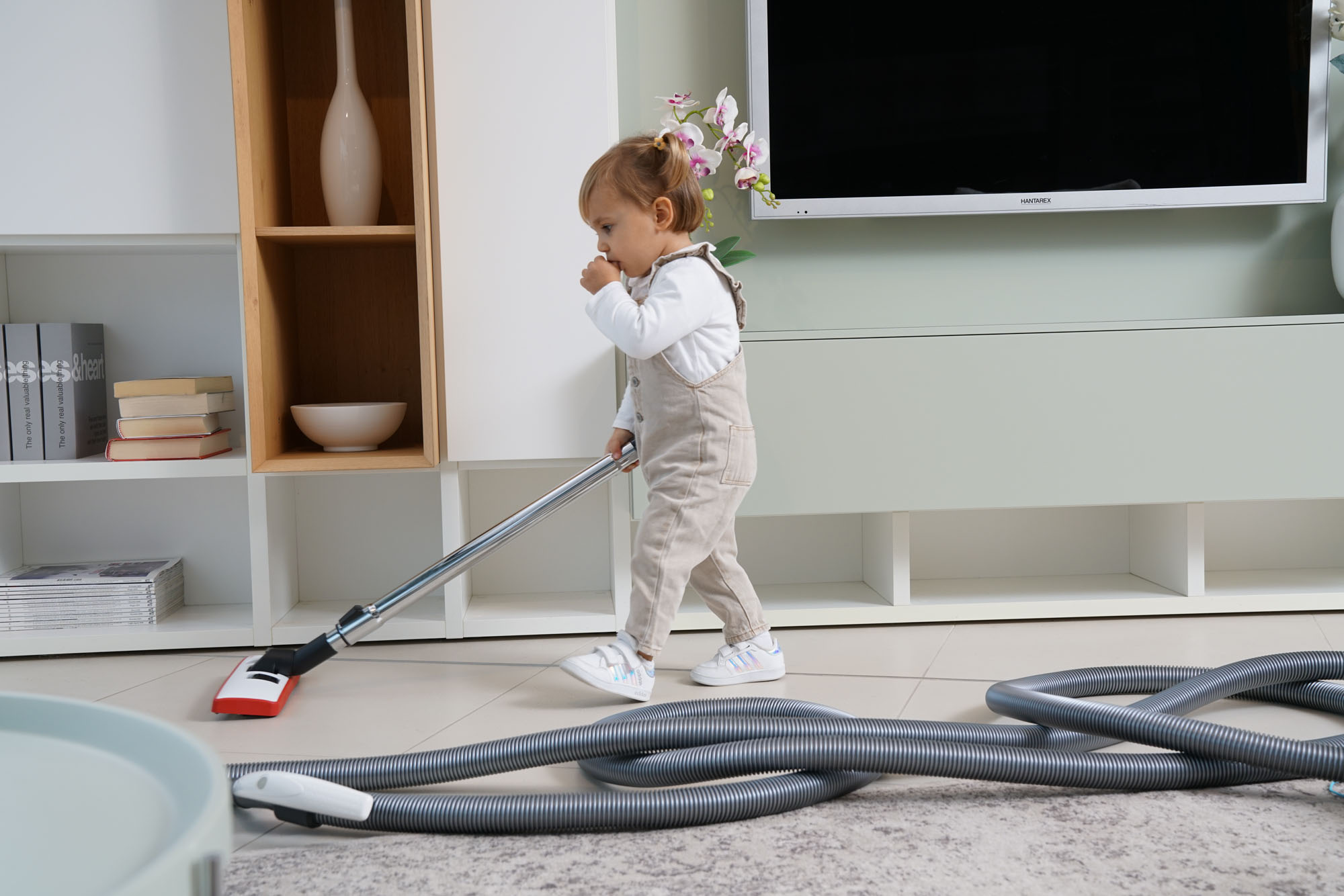 Niña con manguera de aspiración centralizada